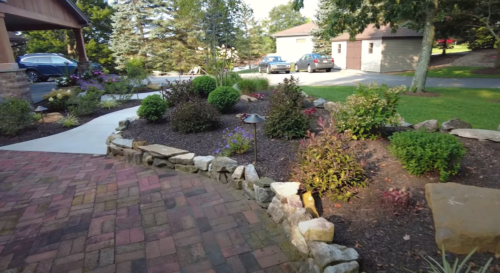 Beautiful hardscaped front yard with stone retaining walls and walkways
